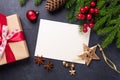 Christmas card with paper, gift box and fir tree branch on stone background. Holiday mockup. Top view