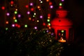 Christmas card. Christmas red glowing lantern with decorated evergreen tree on dark background Royalty Free Stock Photo