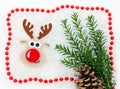 Christmas card red and white, reindeer, christmastree, pine cone, garland in snow