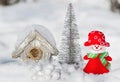 Christmas card snowman girl next to a silvery tree and a bird house,