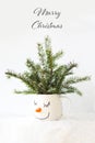 Christmas card snowy tree in a cup with the face of a sleeping snowman. Royalty Free Stock Photo
