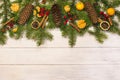Christmas card, spruce branches with cones on a wooden light background decorated with tangerines. Top view Royalty Free Stock Photo