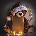 Christmas card with Teddy bear holding a place for text and other Christmas decor light garland Royalty Free Stock Photo