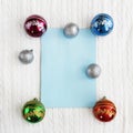 Christmas card with toys New Year`s balls on a white fabric background with a braid pattern