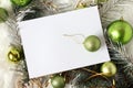 Christmas card with white text background and green Christmas balls and shiny tinsel, top view Royalty Free Stock Photo