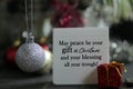 Christmas card and wishes on a notepaper - May peace be your gift at Christmas and your blessing all year trough.