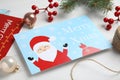 Christmas cards and festive decor on white wooden background