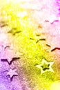 Christmas celebration. Abstract background for new year party. Patter of gold stars with lights, bokeh over neon color background Royalty Free Stock Photo