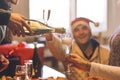 Group of friends drinking and toasting together - a hand with bottle pouring sparkling wine in a glass flute Royalty Free Stock Photo