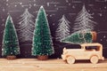 Christmas celebration concept with Christmas tree on toy car on wooden table over chalkboard background Royalty Free Stock Photo