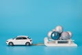 Christmas celebration concept. Close up photo of toy mini car carrying white wooden sledge with little baubles  isolated on blue Royalty Free Stock Photo