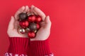 Christmas celebration concept. Top above overhead view photo of female hands in sweater holding pile of small baubles isolated on Royalty Free Stock Photo