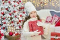 Christmas celebration. Cute little girl in a beautiful dress sitting near the Christmas tree. Christmas miracles. Luxurious Christ Royalty Free Stock Photo