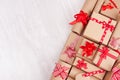 Christmas celebration gifts with red ribbons and bows closeup on white wood background, copy space, top view. Royalty Free Stock Photo