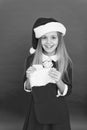 Christmas celebration ideas. Child Santa Claus costume hold stocking. Happy smiling face. Emotional baby. Good vibes