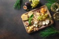 Christmas cheese platter with grapes, nuts, figs on brown background. Top view. Copy space Royalty Free Stock Photo