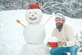Christmas chef cook. Man in snow. Winter portrait of handsome cook in snow Garden with snowman.