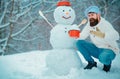 Christmas chef cook. Christmas Man and snowman on white snow background. Handsome Winter Man with snowman in frosty