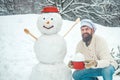 Christmas chef cook. Winter portrait of handsome cook in snow Garden with snowman.