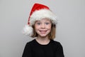 Christmas child girl in Santa hat looking at camera on white background, Xmas portrait Royalty Free Stock Photo