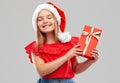 Pleased girl in snata hat with christmas gift Royalty Free Stock Photo