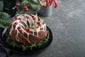 Christmas chocolate bundt cake. Traditional Christmas fruit cake with white glaze, cranberries and rosemary on dark backgroundChri Royalty Free Stock Photo