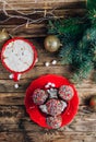 Christmas Chocolate cake pops on red plate with mug of coffee with marshmallows Royalty Free Stock Photo