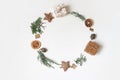 Christmas circle floral composition. Wreath of juniperus branches, pine cones, gift boxes, wooden stars and dry orange