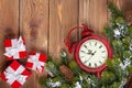 Christmas clock over wooden background with snow fir tree and gi Royalty Free Stock Photo