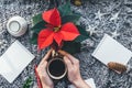 Christmas closeup mockup with cup of coffee poinsettia and hands with copy place. Cozy background Royalty Free Stock Photo
