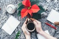 Christmas closeup mockup with cup of coffee poinsettia and hands with copy place. Cozy background Royalty Free Stock Photo