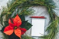 Christmas closeup mockup with poinsettia, pine wreath, notebook, with copy place Royalty Free Stock Photo