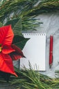 Christmas closeup mockup with poinsettia, pine wreath, notebook, with copy place Royalty Free Stock Photo