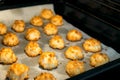 Christmas coconut puffs macaroon cookies on parchment paper on tray in oven. Festive cozy home atmosphere. Holiday pastry baking Royalty Free Stock Photo