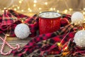 Christmas coffee in a red cup with marshmallows and plaid. Decorated white balls candy cane and light garland bokeh Royalty Free Stock Photo