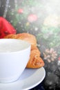 Christmas coffee vertical card. White glass cup hot cappuccino with croissants and christmas decoration on background