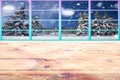 Christmas on a cold winter frozen wooden table with a colorful window framework and snow forest landscape