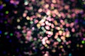 Christmas colorful light black overlay background. Defocused violet and pink bokeh. Holiday garland decor Royalty Free Stock Photo