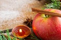Christmas composition: apple candle and cinnamon stick.