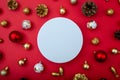 Christmas composition with baubles and pinecones on red background. White circle in the center as copy space for text or logo. Royalty Free Stock Photo