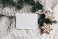 Christmas composition. Blank cotton card mockup, star shaped gingerbread cookies and fir tree branches. White muslin Royalty Free Stock Photo