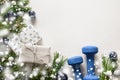 Christmas composition with blue dumbbells, gift, fir branches on white. Copy space. Xmas greeting card Royalty Free Stock Photo