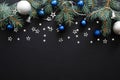 Christmas composition with blue and sliver modern decorations, baubles, fir tree branches on dark black background. Elegant Royalty Free Stock Photo