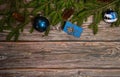 The border is made of spruce branches, cones, gift box and blue Christmas balls on a wooden background. Christmas, winter, New yea Royalty Free Stock Photo