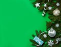 The border is made of spruce branches, white balls, snowflakes, paper streamer and gift box on a green background. Royalty Free Stock Photo