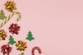 Christmas composition with bows, candy canes and felt fir trees on pastel pink background with copy space. Creative concept for