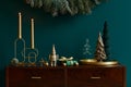 Christmas composition on brwon wooden commode with decoration, christmas tree, gifts and accessories in cozy home decor.