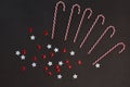 Christmas composition. Caramel striped candy canes and red with white stars on a dark gray background Royalty Free Stock Photo