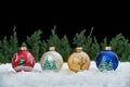 Christmas composition with Christmas balls on the snow flakes and defocused Christmas tree branches in the background Royalty Free Stock Photo