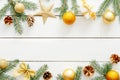 Christmas composition. Christmas frame with golden decorations, ornaments, balls, stars, gifts, pine cones, bow on wooden white Royalty Free Stock Photo